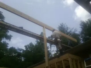 Carpenter setting a ridge beam over a new addition frame — Ice Dam Removal by Roofing Brothers in Rising Sun