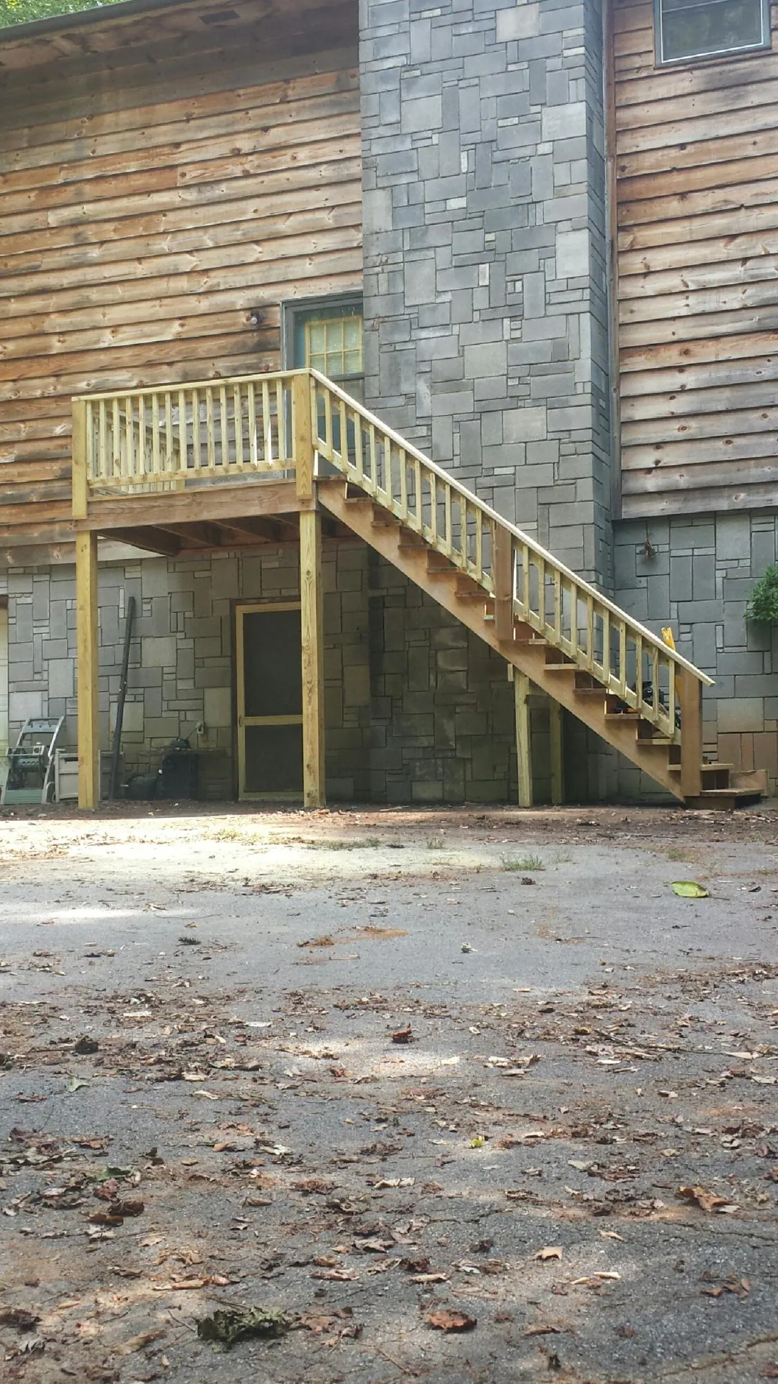 New pressure treated deck and stair landing on a log home in Rising Sun
