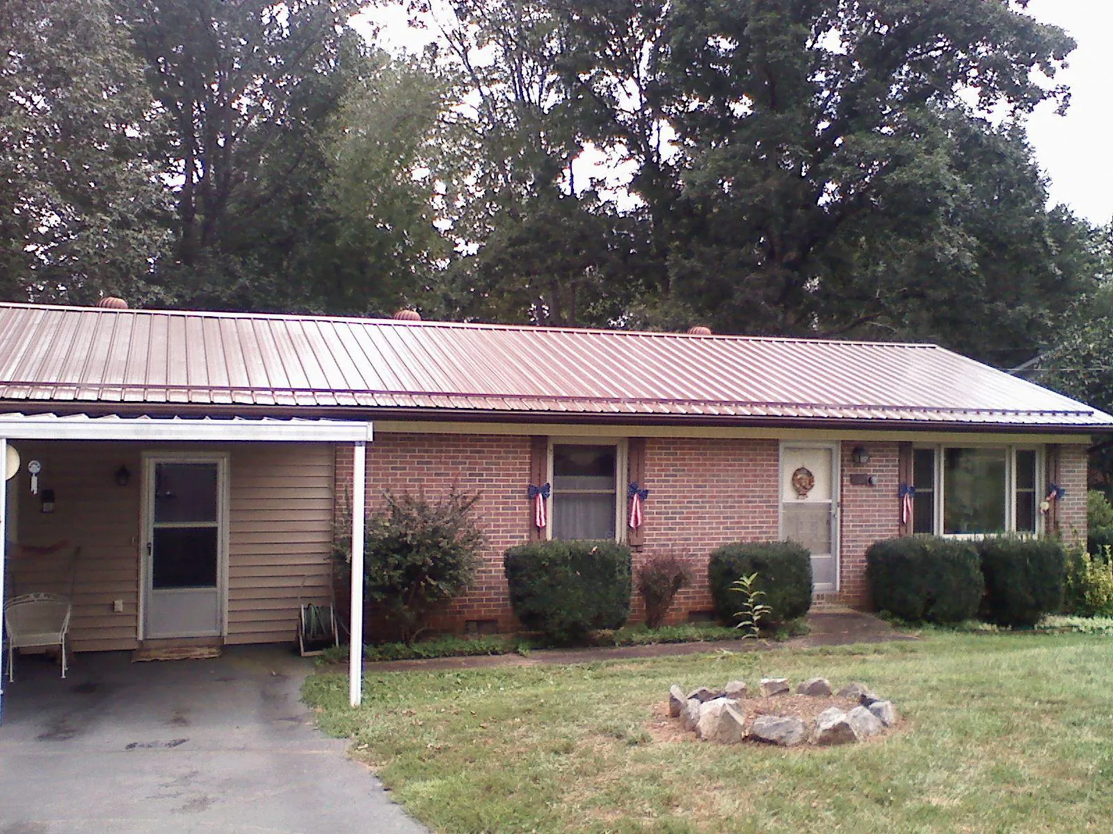 Bronze metal roof and carport on a brick ranch home — Roof Repair work by our crew in Rising Sun